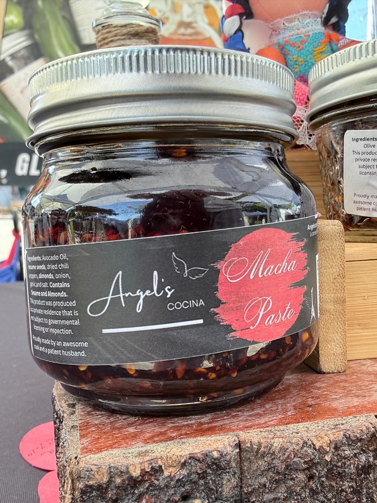 8 oz jar of Angel's Cocina Salsa Macha Paste with almonds and sesame in avocado oil, on the stand at a Houston farmers market